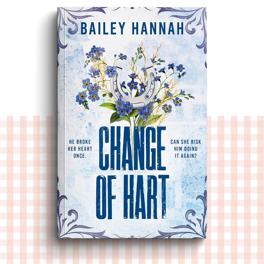 Paperback book cover of 'Change of Hart' by Bailey Hannah with flowers and horseshoe on a light blue background.