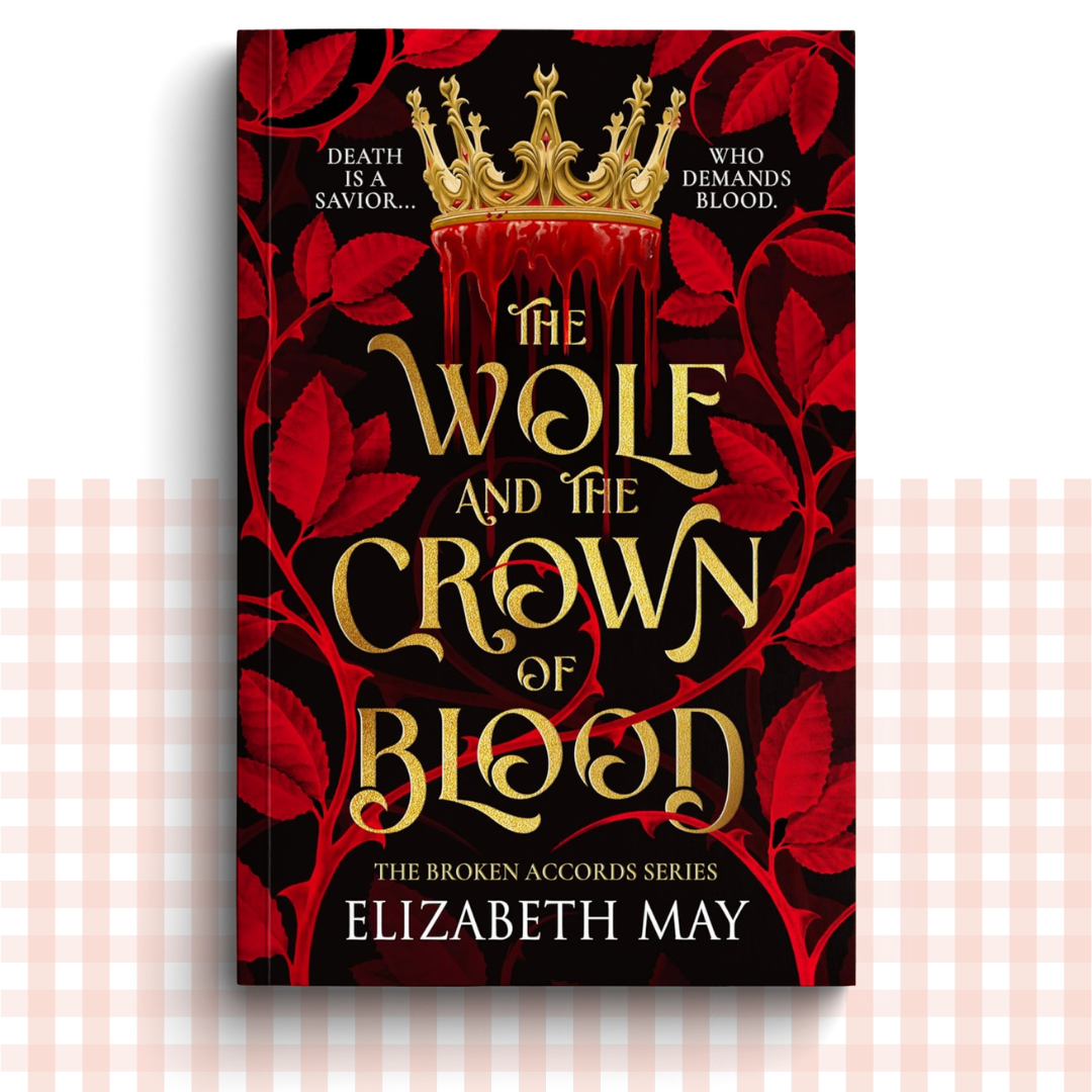Paperback book cover of 'The Wolf and the Crown of Blood' by Elizabeth May with gold text and red leaves on a black background.