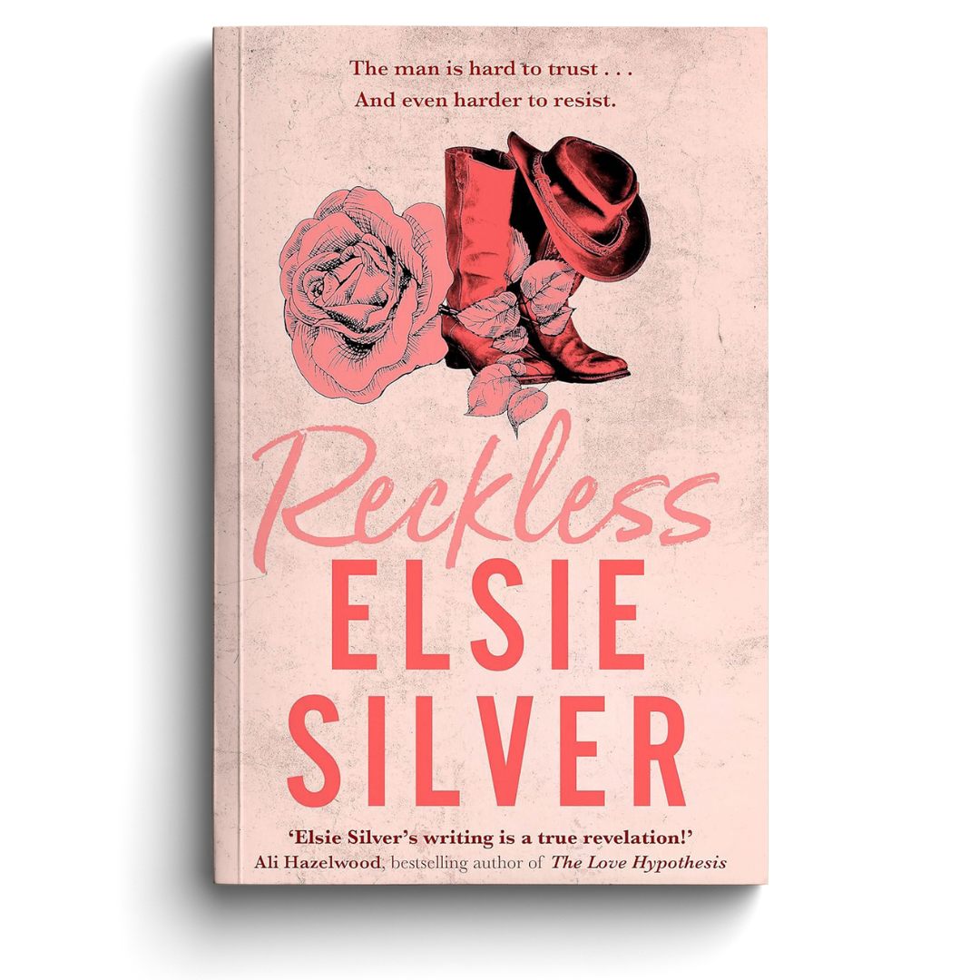 Book cover of 'Reckless' by Elsie Silver with cowboy boots and a rose on a pink background.