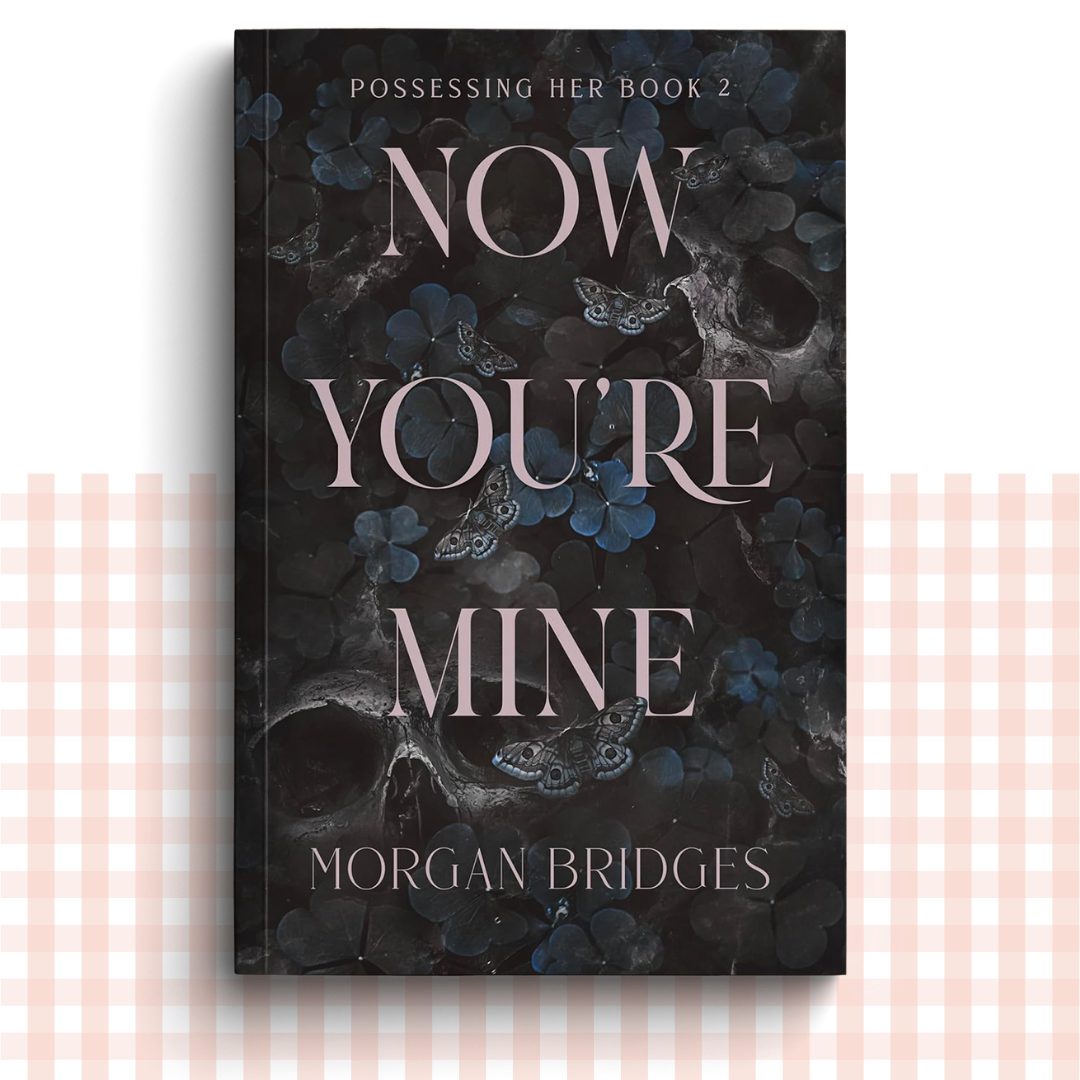 Paperback book cover of 'Now You're Mine' by Morgan Bridges with a dark floral and butterfly design.