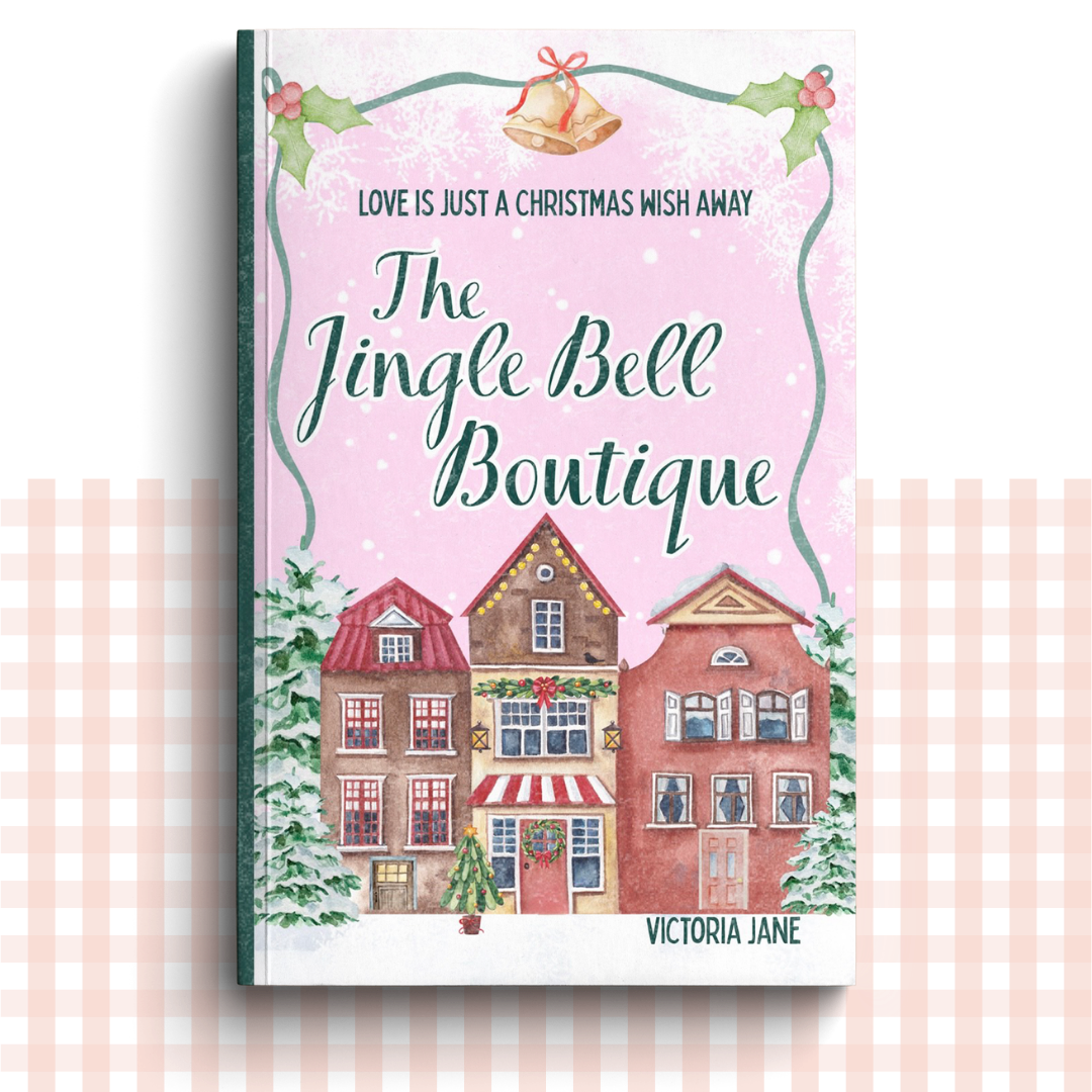 Paperback book cover of 'The Jingle Bell Boutique' by Victoria Jane with a festive village design
