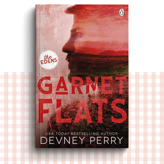Paperback book cover of 'Garnet Flats' by Devney Perry with a red landscape design and a man's side profile.