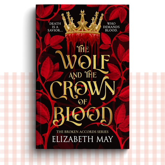 Paperback book cover of 'The Wolf and the Crown of Blood' by Elizabeth May with gold text and red leaves on a black background.
