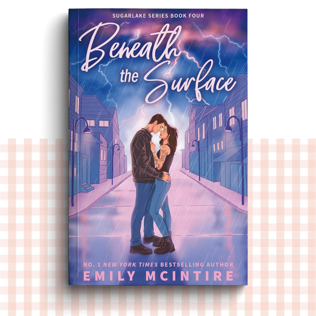 Paperback book cover of 'Beneath the Surface' by Emily McIntire with a couple embracing in the street under lightning.