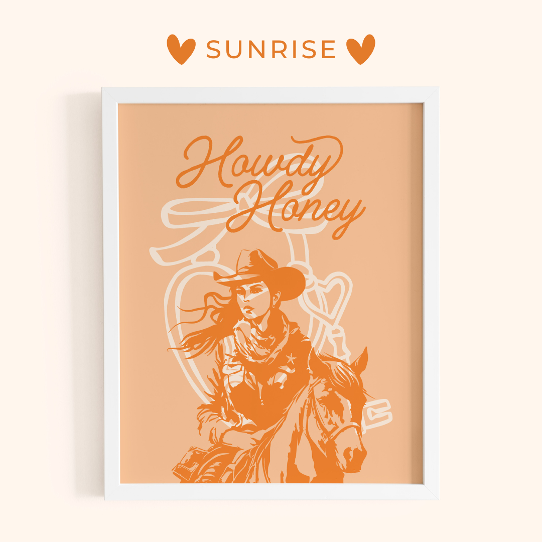 Framed artwork with a cowboy and 'Howdy Honey' text on a peach background, featuring the brand 'Sunrise'.