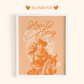 Framed artwork with a cowboy and 'Howdy Honey' text on a peach background, featuring the brand 'Sunrise'.