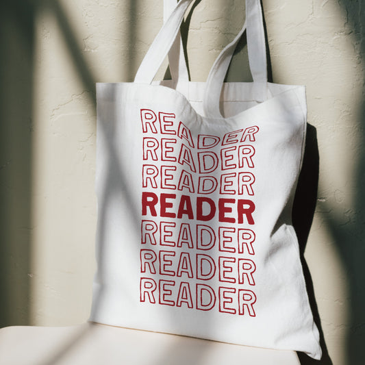 White tote bag with 'READER' text in red on a neutral background