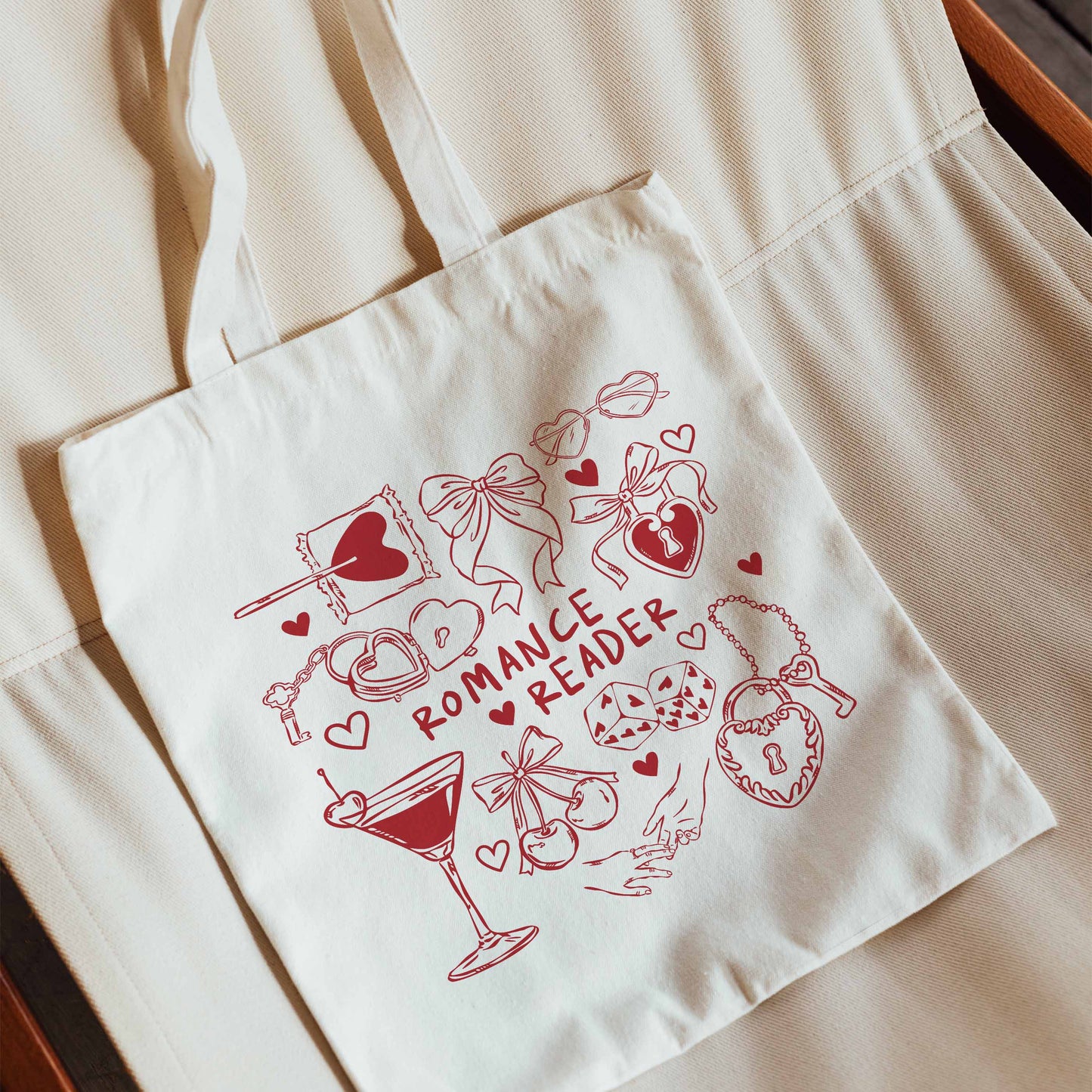 White tote bag with red 'Romance Reader' design featuring hearts, a martini glass, and other romantic elements.