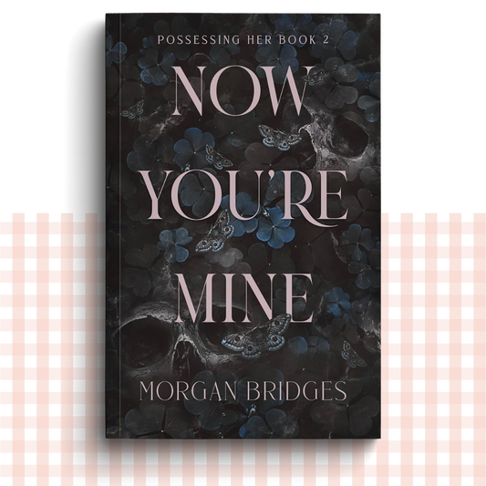 Paperback book cover of 'Now You're Mine' by Morgan Bridges with a dark floral and butterfly design.