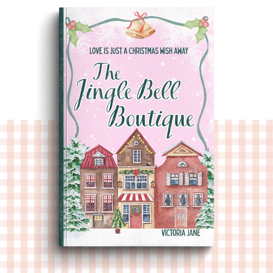 Paperback book cover of 'The Jingle Bell Boutique' by Victoria Jane with a festive village design